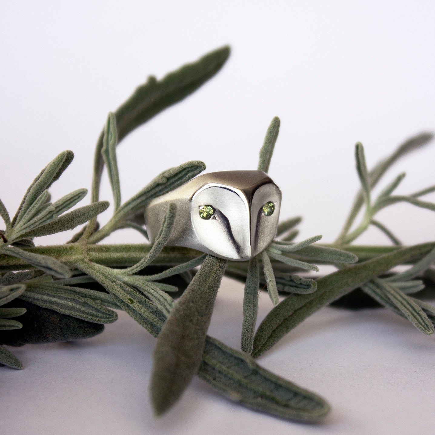 Handmade owl ring in sterling silver with sage green sapphires, part of the animal jewelry collection by Elina Gleizer.