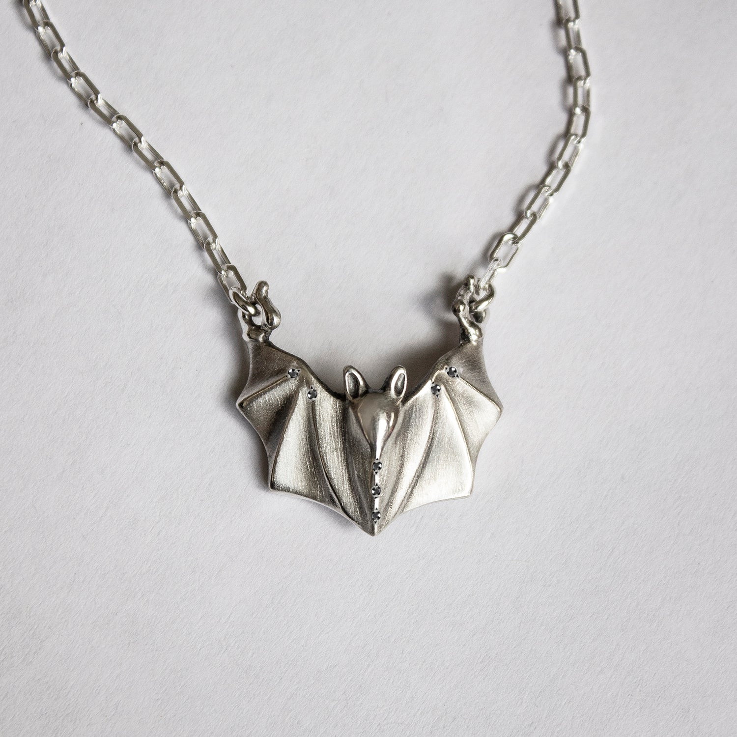 Sterling silver bat necklace with black diamonds on paperclip chain by Elina Gleizer